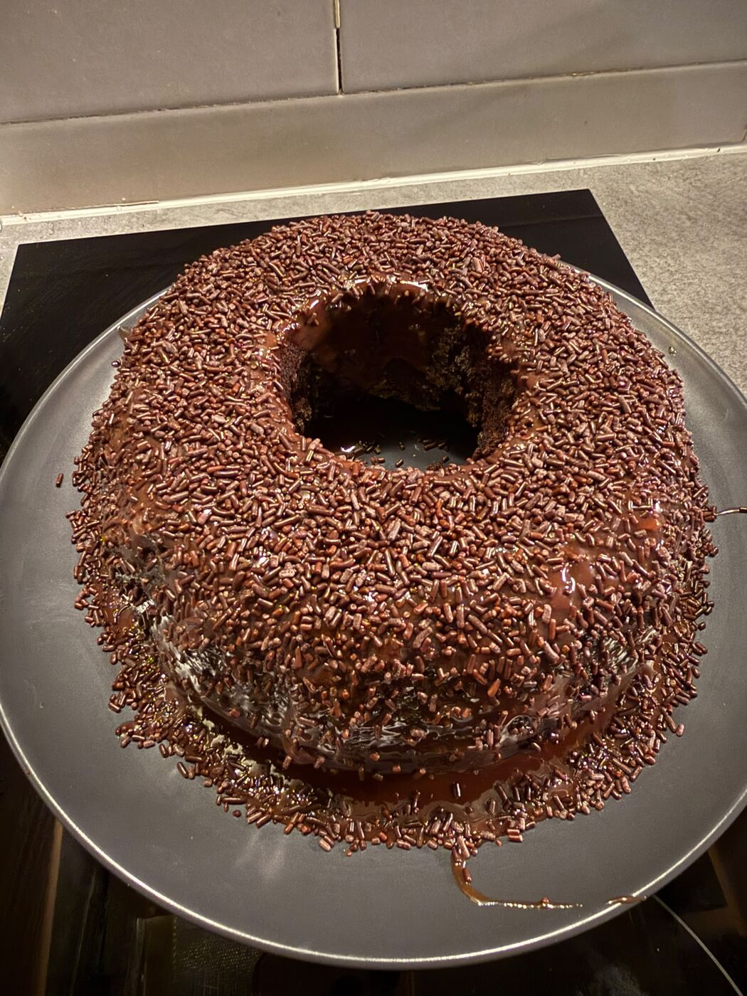 Bizcocho de chocolate en forma de corona, bañado y cubierto de fideos de chocolate