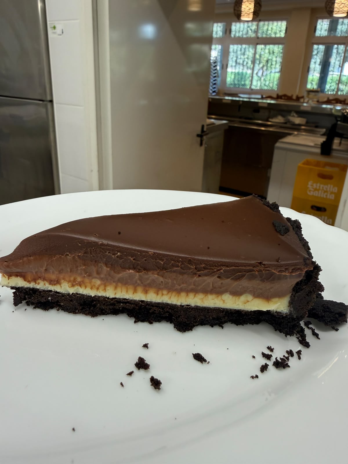 Porción de tarta holandesa con base de galleta de chocolate y capas de chocolate blanco, con leche y negro